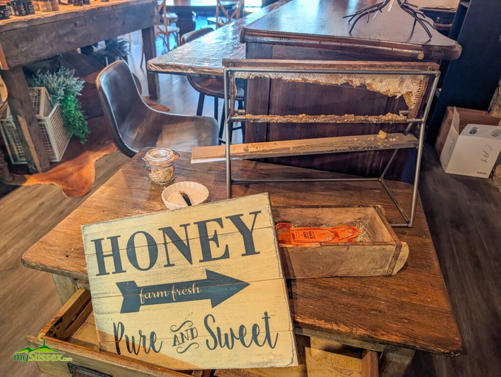 A honeycomb frame display at Curd & Cleaver, where fresh honeycomb is served straight from the frame as part of the shop’s specialty food offerings.
