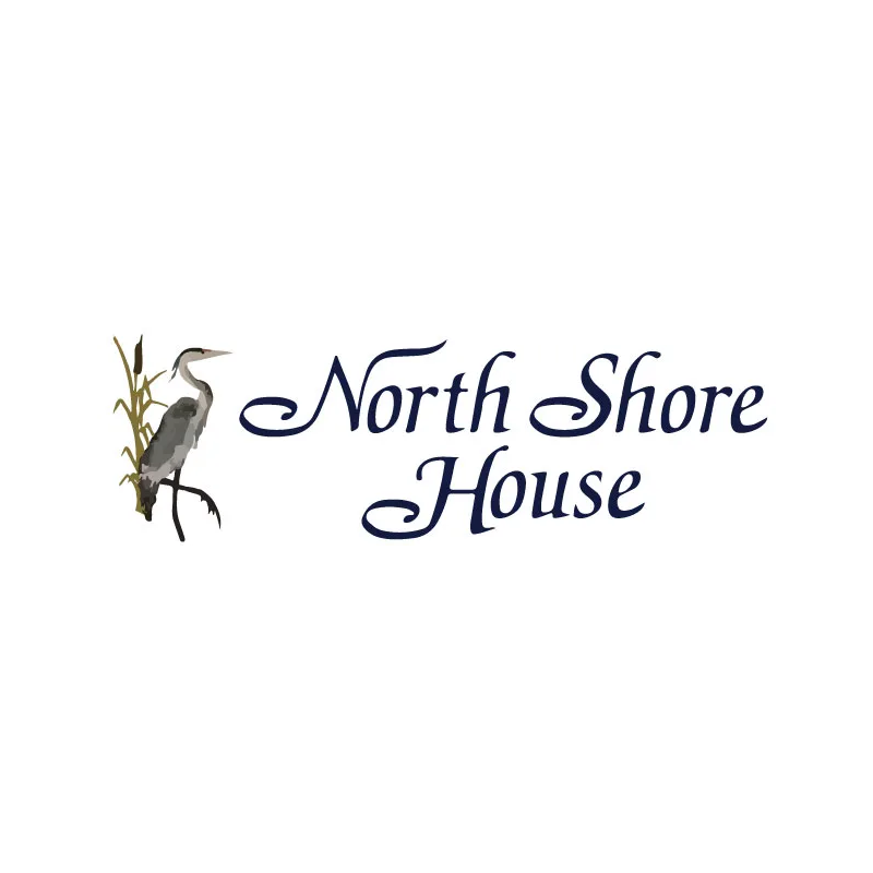 Blue heron perched on marsh grass next to North Shore House text in navy script