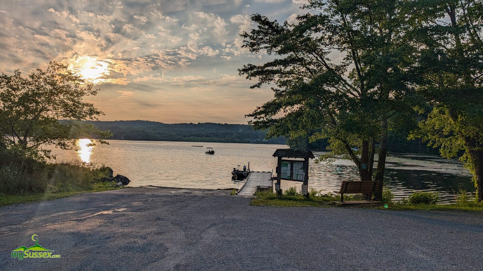Boat approaching the launch on Swartswood Lake at sunset.