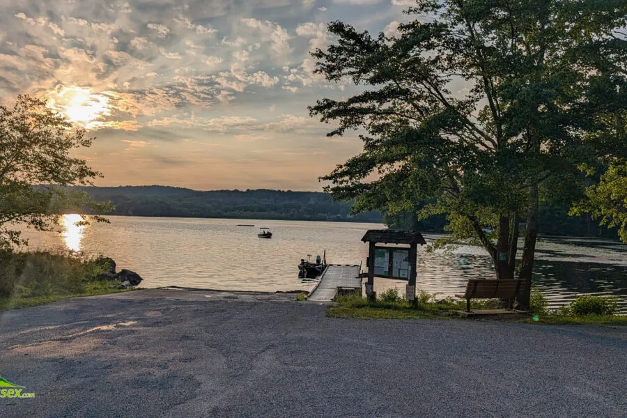 Boat approaching the launch on Swartswood Lake at sunset.