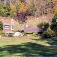 Stokes State Forest entrance sign beside a fire danger warning sign featuring Smokey Bear.