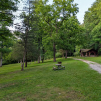 Picnic tables and a group picnic pavilion beside Swartswood Lake.