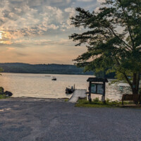 Boat approaching the launch on Swartswood Lake at sunset.